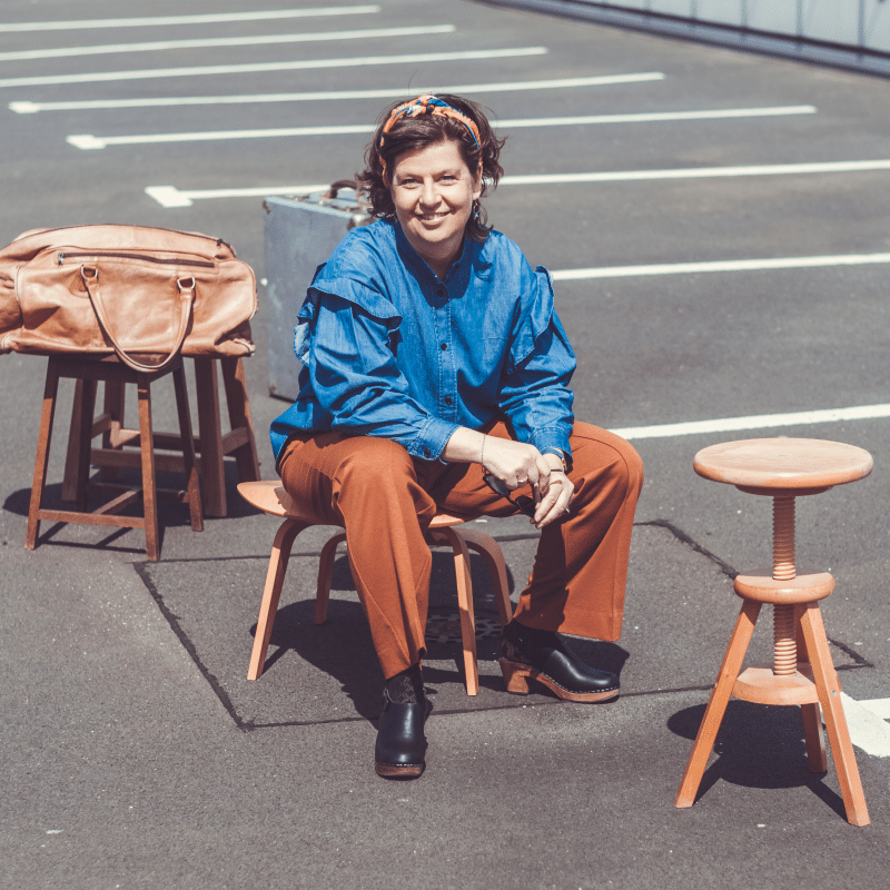 Frau sitzt auf einem Holzhocker